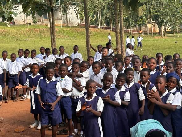 Secondary school students in uniform gathered outdoors
