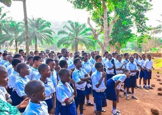 A large crowd of secondary school students in blue and white uniforms