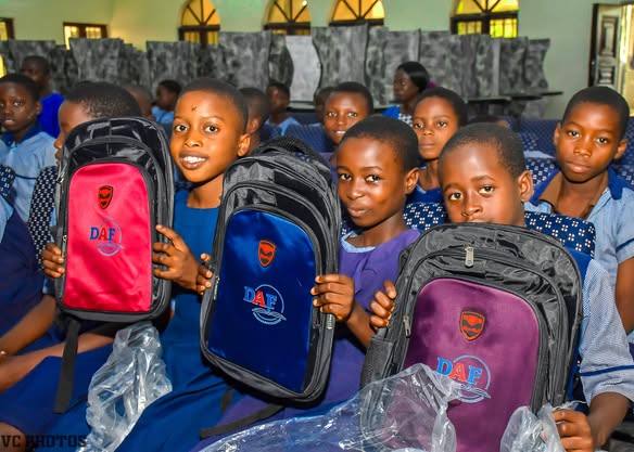 Primary school pupils holding new backpacks from the Project Hope backpack drive