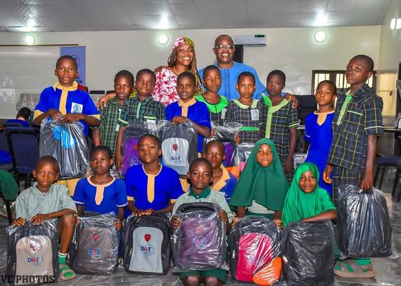 Pupils seated in a hall with new school bags
